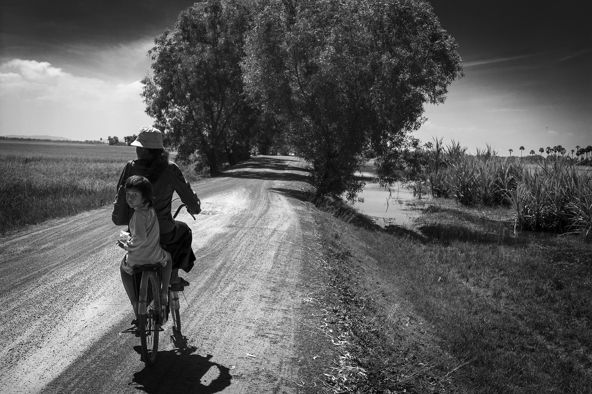 Niña con su madre en bicicleta por Cambodia